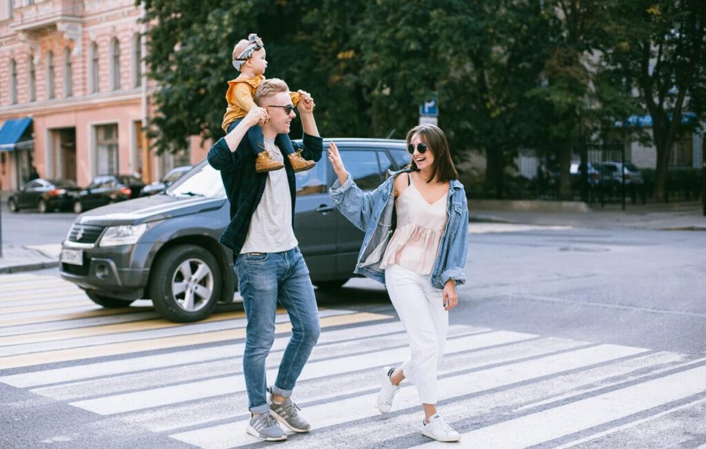 Family laughing and walking on a pedestrian lane