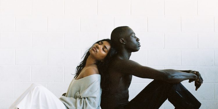 Coronavirus And Floyd Death: Health Of Black People Suffers 1 Black man and woman sitting back to back feeling depressed