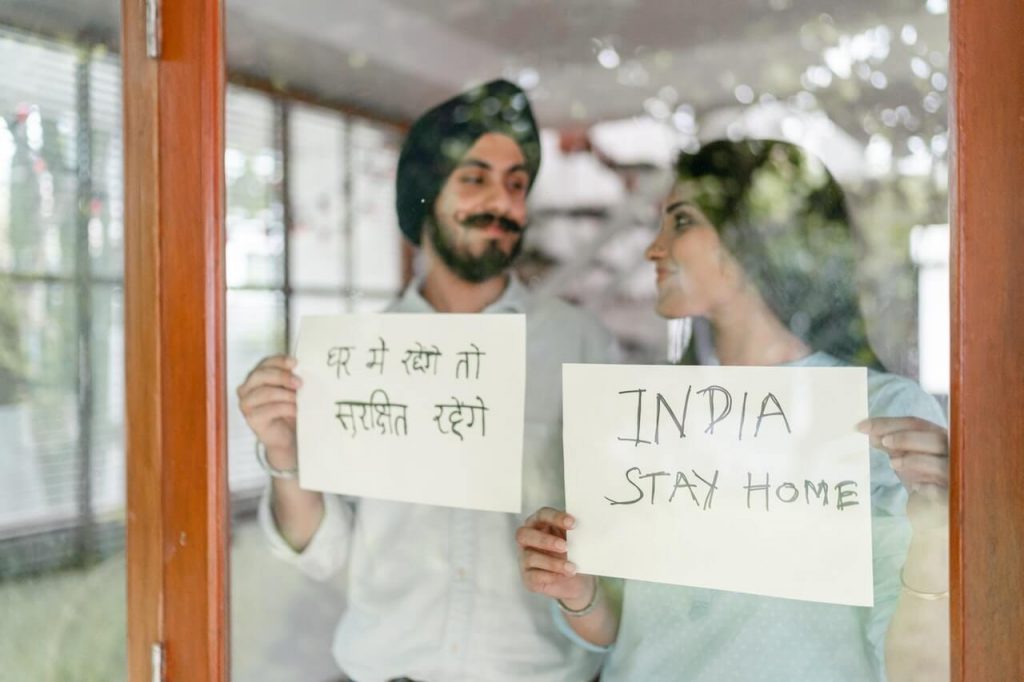 Couple holding display cards with message to Stay at Home