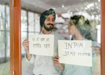 Couple holding display cards with message to Stay at Home