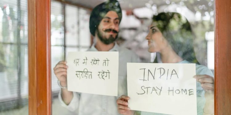 Coronavirus Cases Surge Across India and South Africa 1 Couple holding display cards with message to Stay at Home