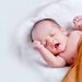 Coronavirus: Mothers Unlikely To Infect Baby During Childbirth 7 Image of a Newborn baby lying on fur pillow in brown blanket
