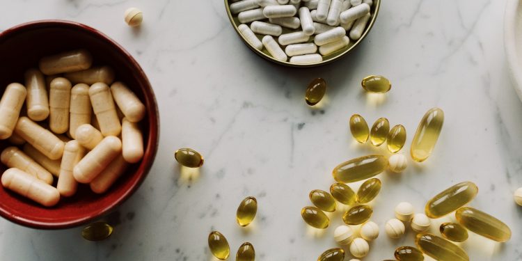 Vitamin D Does Not Prevent or Treat COVID-19: Experts Say 1 a table with vitamin D supplements on shelf and bowls