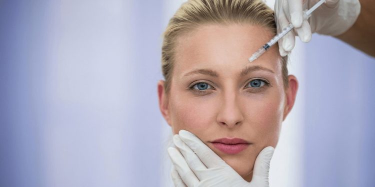 Image of a woman receiving Botox injection by a dermatologist