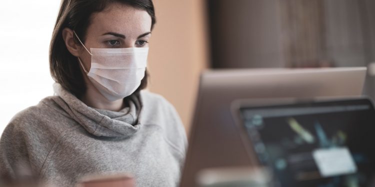 Majority Testing Positive For Coronavirus Have No Symptoms 1 woman working and wearing mask