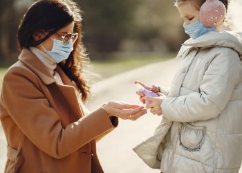 Antiseptic Effective In Fighting Coronavirus, Flu, And HPV 12 Image of daughter spraying antiseptic on hands of mother