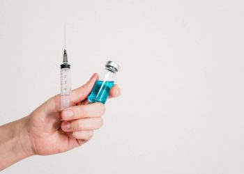 Doctor hands holding COVID-19 vaccine and injection