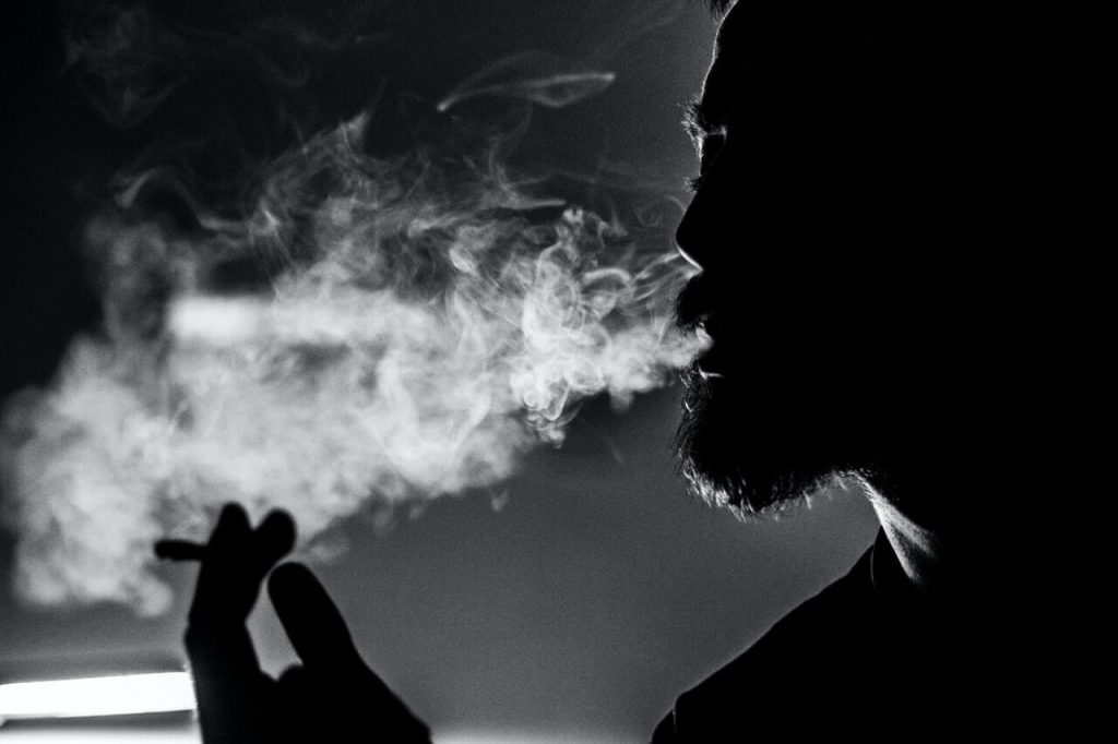Man holding cigarette and smoking