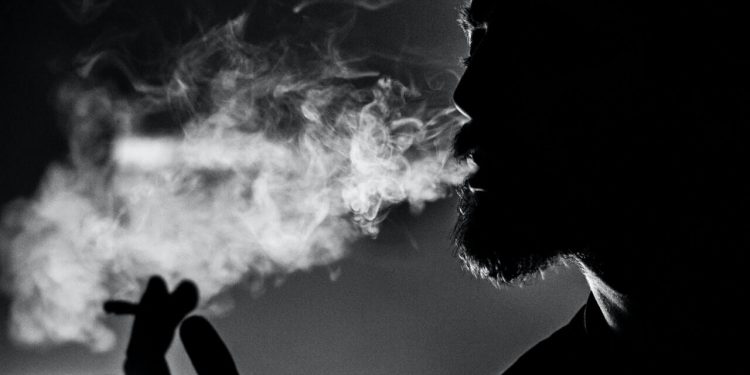 COVID-19: People Are Taking Steps To Quit Smoking 1 Man holding cigarette and smoking