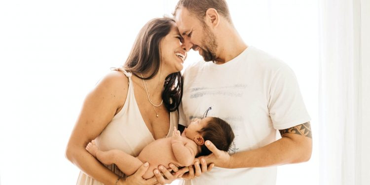 Not Every Woman Needs A Pain Reliever During Childbirth 1 Image of Mother and father holding newborn baby and laughing