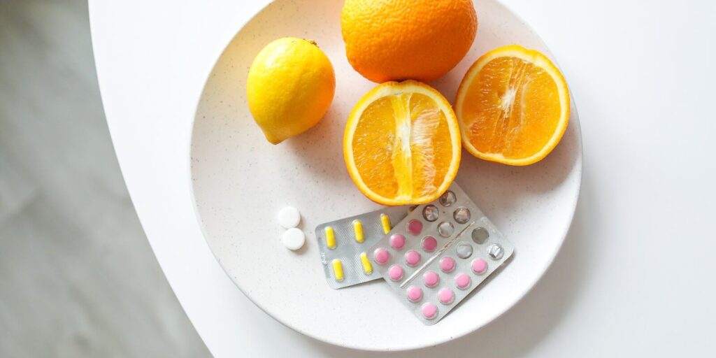 Image of medicines and oranges on a white plate