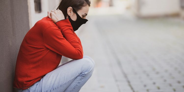 Pandemic Potential: Swine Flu Spreading in China 1 Woman sitting on a footpath feeling distressed