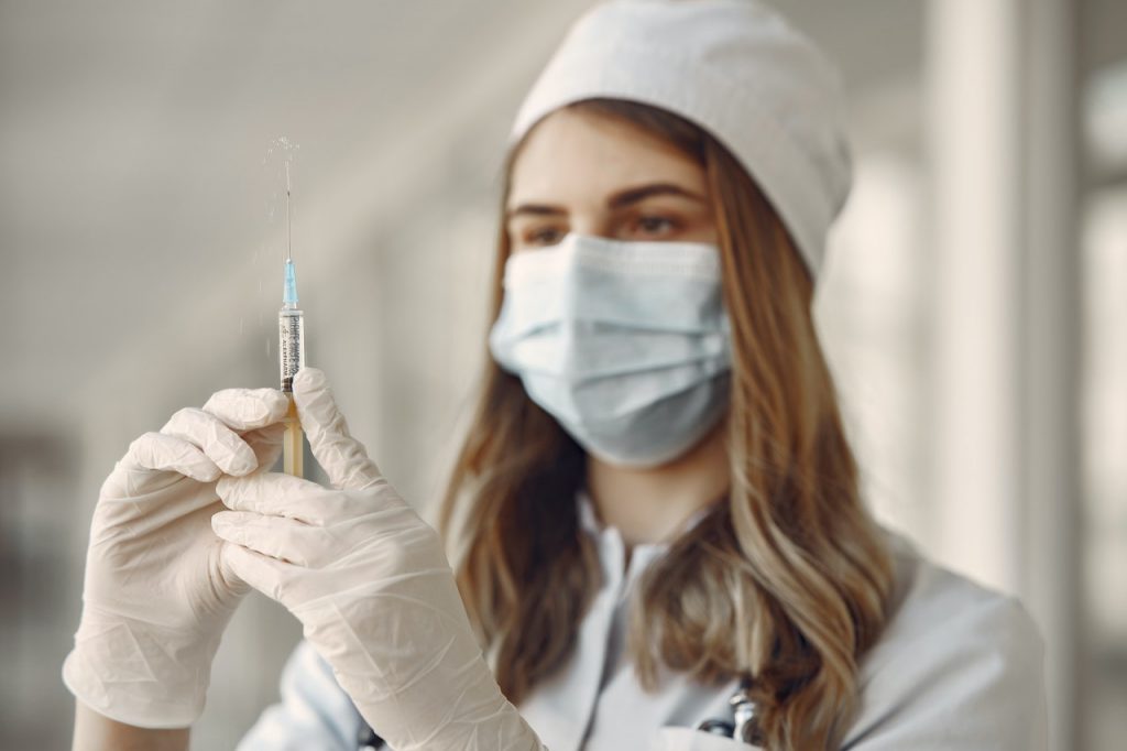 Doctor holding a vaccine syringe