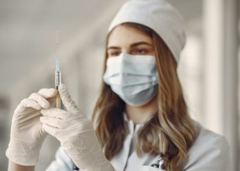 MMR Vaccine Could Prevent COVID-19 Symptoms 12 Doctor holding a vaccine syringe