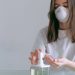 People Wearing Masks Follow Protective Measures Of Hand Washing In Coronavirus, Study Suggests 7 Image of a woman in white shirt, wearing a masks and using hand sanitizer