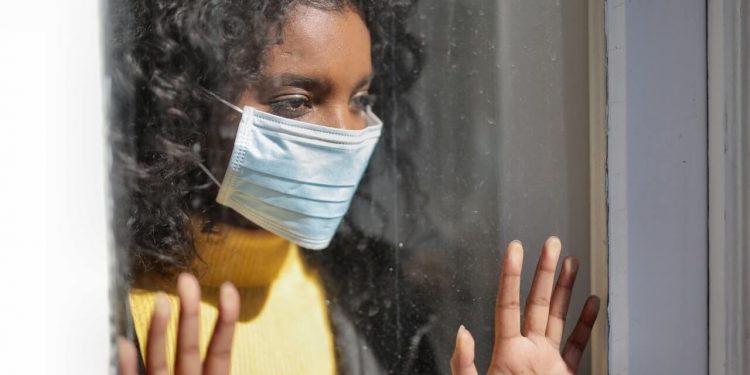 CDC Released Data On COVID-19 Deaths 1 A serious young ethnic woman at home wearing medical mask
