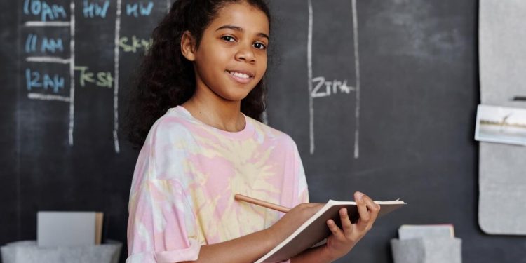 Young People Spread Coronavirus Like Adults 1 Young girl in school holding notepad and pencil