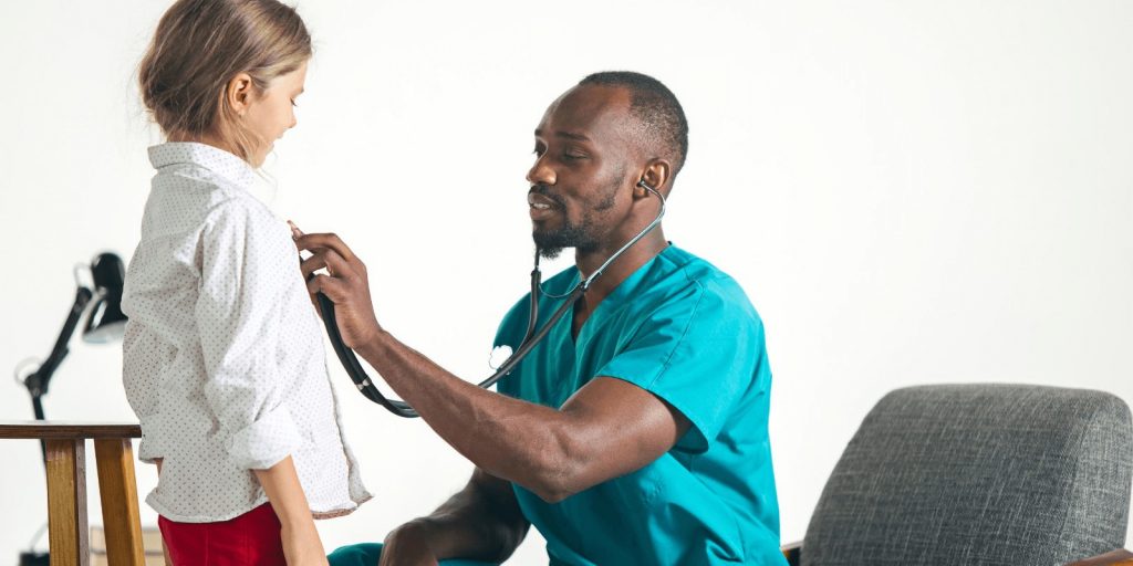 Doctor examining a teenage girl with stethoscope