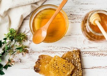 Honey Beats Antibiotics For Treatment Of Cough And Cold 5 Image of Honey jar with honeycomb on a solid surface with herbs
