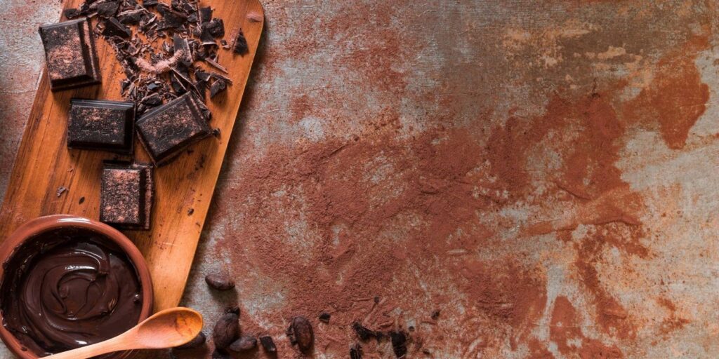 Melted and crushed dark chocolate chunk on a cutting board