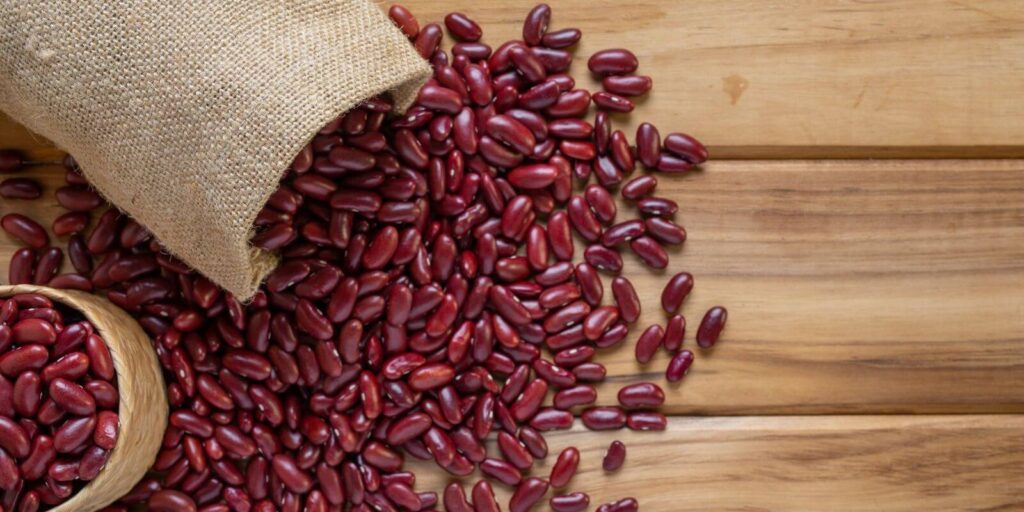 Red kidney beans in brown sack on a wooden background