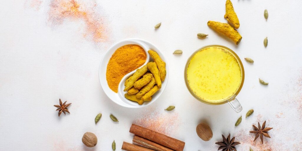 Turmeric powder and turmeric milk paste on a marble background