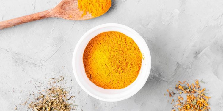 Turmeric: Health Benefits And Nutritional Components 1 Turmeric powder in white bowl on a marble background