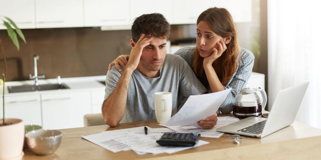 Young couple feeling stressed checking the family budget